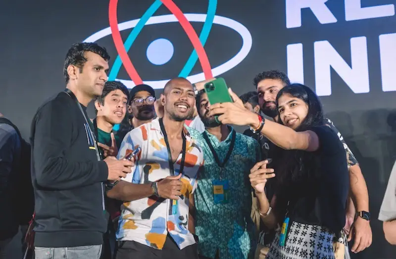 Pessoas tirando uma selfie em grupo no React India